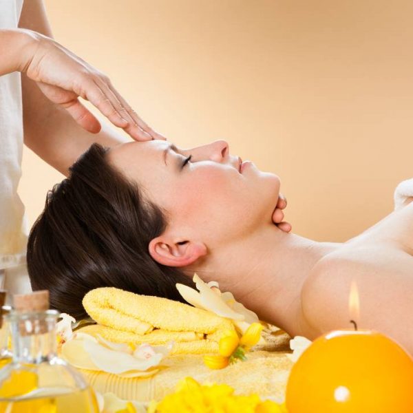 Woman Receiving Head Massage In Spa Side view of young woman receiving head massage in spa