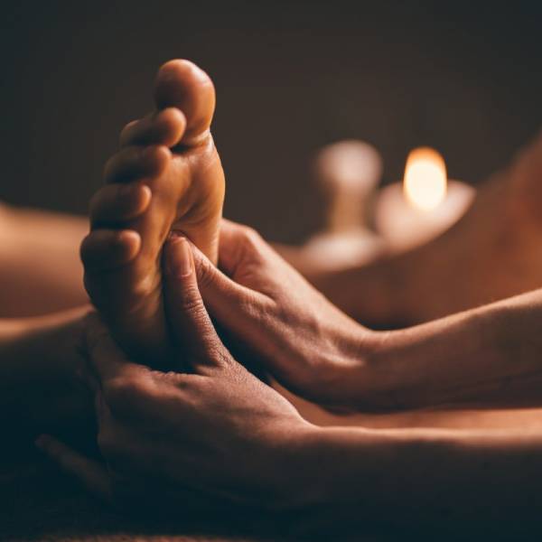 Professional foot massage close up. Authentic shot of luxury spa treatment. Charming light. Shallow depth of field. Stylized and colored.